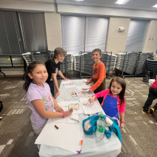 four children at table making a craft